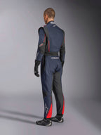 Combinaison Alpinestars GP Tech V4, Bleu Marine Noir Rouge, vue arrière latérale d'une combinaison de course automobile professionnelle une pièce, avec des accents rouges et des panneaux noirs, portée avec des gants et des chaussures de course noirs, équipement de sport automobile certifié FIA.