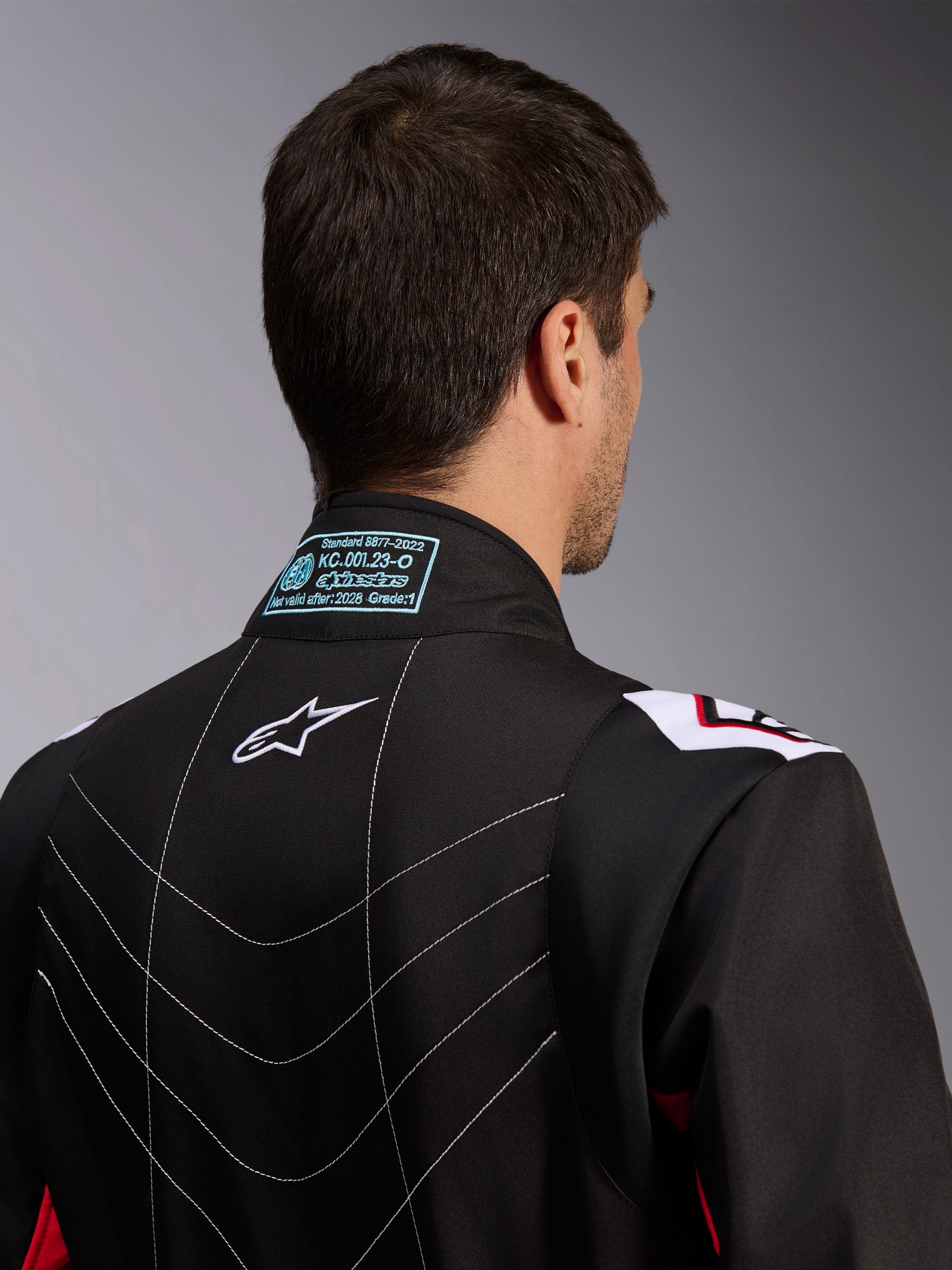 Alpinestars KMX-9 V3 Suit, Karting Suit, Black Red White, back view of collar showing FIA 8877-2022 homologation label, white Astars logo, and decorative stitching details