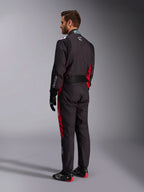 Combinaison Alpinestars KMX-9 V3 Graphic 3, noir et rouge, vue arrière d'un mannequin portant un équipement complet de karting comprenant des gants noirs et des bottes de course, avec des panneaux latéraux rouges et des détails de logos blancs.