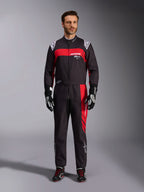 Combinaison Alpinestars KMX-9 V3 Graphic 3, combinaison de karting, noir et rouge, vue frontale en pied portée par un mannequin, avec des empiècements graphiques rouges et des logos blancs, associée à des gants et des chaussures de course noirs, équipement de sport automobile professionnel.