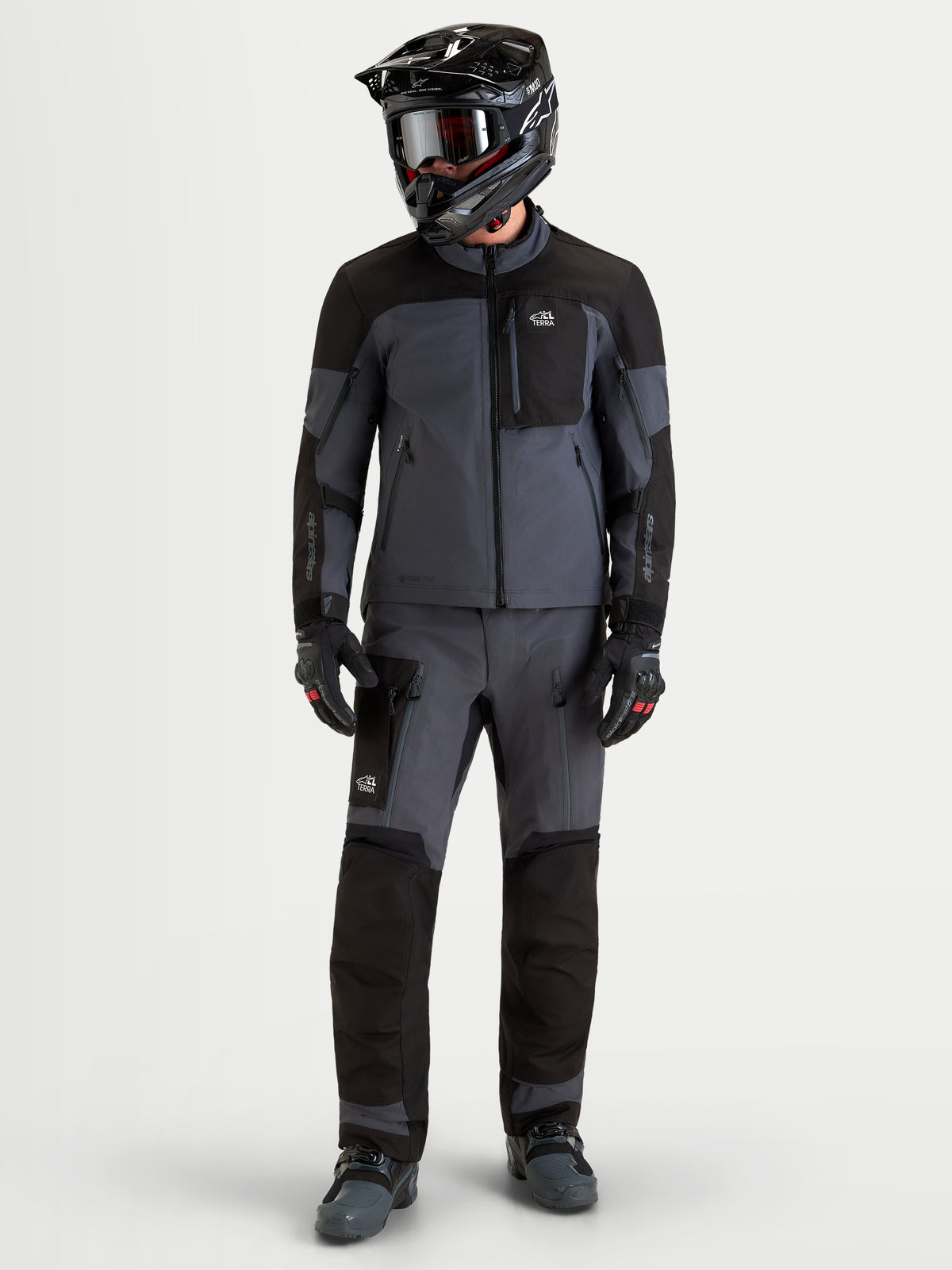 Alpinestars Arenis Gore-Tex Tenue complète, tenue de moto adventure pour homme noire et gris foncé, vue de face en studio sur un modèle portant l'équipement complet avec casque et gants