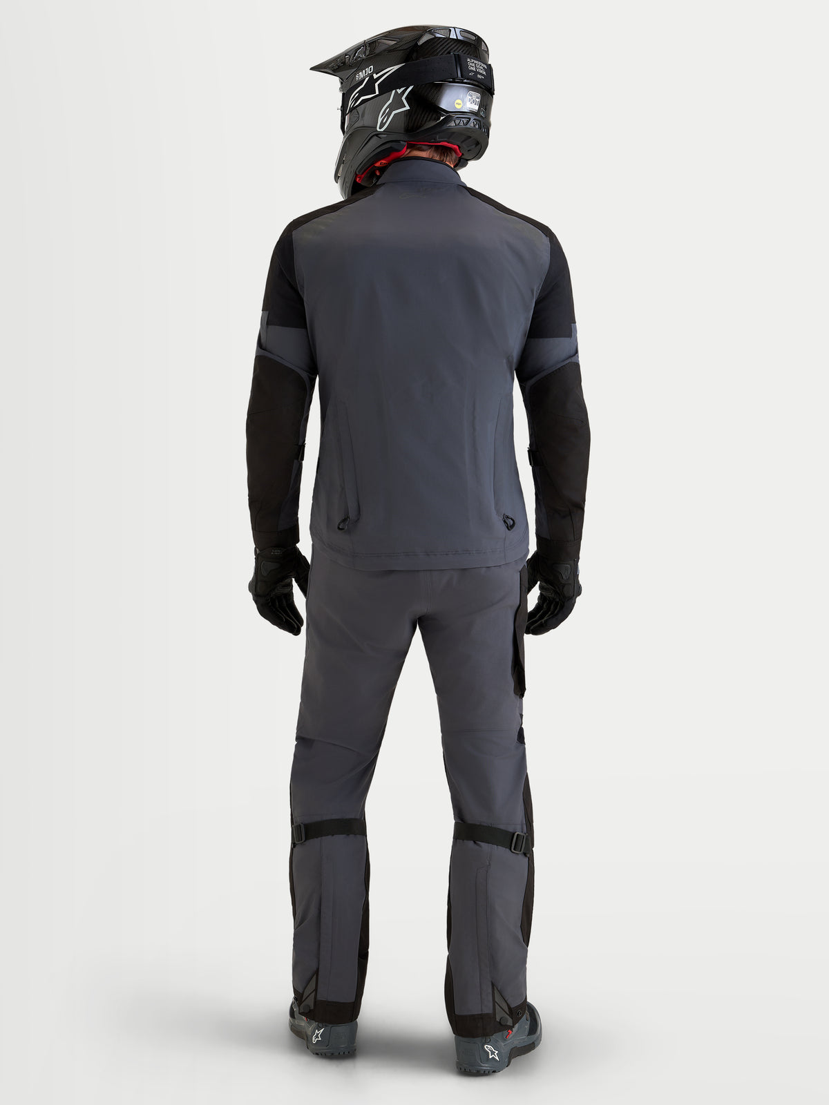 Alpinestars Arenis Gore-Tex® Gear Set, tenue complète de moto adventure pour homme, gris foncé et noir, vue de dos sur un modèle portant un casque assorti et des équipements imperméables GORE-TEX