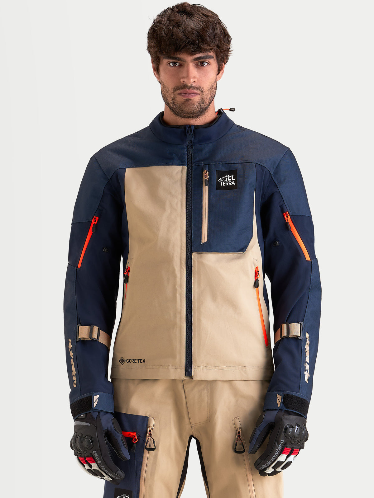 Alpinestars Arenis Gore-Tex Veste, veste de moto adventure pour homme en bleu marine et aluminium, vue de face sur un modèle portant des gants et une tenue assortis, construction étanche