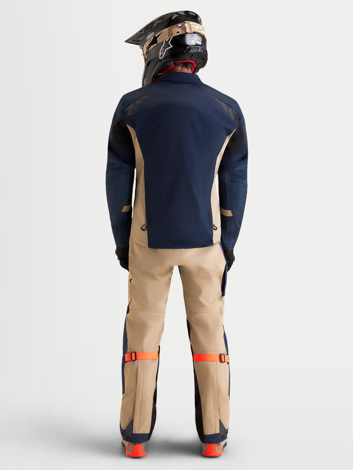 Alpinestars Arenis Gore-Tex Veste, veste de moto adventure pour homme en bleu marine et beige, vue de dos montrant la construction textile imperméable et un pilote portant un équipement de moto