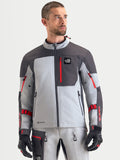 Alpinestars Arenis Gore Tex Veste, veste de moto adventure pour homme en gris moyen, gris foncé et noir, vue de face portée par un modèle mettant en valeur la construction textile imperméable et la poche de poitrine zippée