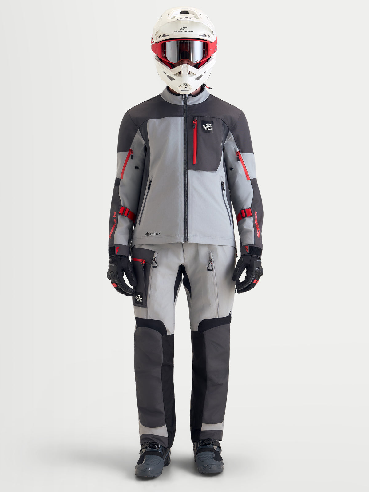 Alpinestars Arenis Gore-Tex Veste, veste de moto adventure pour homme gris moyen, gris foncé et noir, portée sur un modèle avec un équipement complet incluant casque et pantalon assorti