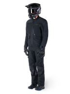 Motocycliste portant la veste Alpinestars St-7 Prime GORE-TEX noire, tenue d'aventure touring coordonnée avec pantalon noir assorti, casque noir avec lunettes et gants, présentant un design épuré et fonctionnel pour des performances par tous les temps.