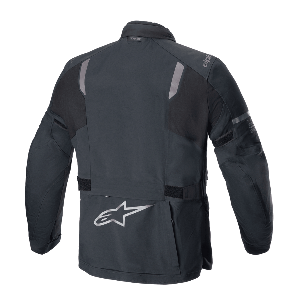 Veste Alpinestars ST-7 2L GORE-TEX, vue arrière, noir et gris foncé, avec panneaux réfléchissants aux épaules, logo étoile Alpinestars argenté dans le bas du dos et sangles de réglage à la taille, équipement de moto adventure touring