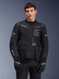 Veste Alpinestars ST-7 2L GORE-TEX, veste de moto touring, noire et gris foncé, avec marquage Alpinestars Exploration Equipment sur la poitrine, grandes poches cargo imperméables, logo GORE-TEX sur la manche, design robuste prêt pour l'aventure avec accents réfléchissants