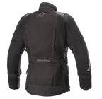Veste Alpinestars Stella Ketchum GORE-TEX pour femme, veste de moto en textile, noire, vue arrière présentant le logo Alpinestars, sangle de réglage à la taille avec marquage et panneaux réfléchissants aux épaules et aux manches pour la visibilité de la pilote.