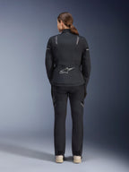 Veste Alpinestars Stella ST-7 2L GORE-TEX pour femme, noir et gris foncé, vue de dos montrant le logo Alpinestars argenté au bas du dos, associée à un pantalon textile noir assorti, équipement de moto adventure touring