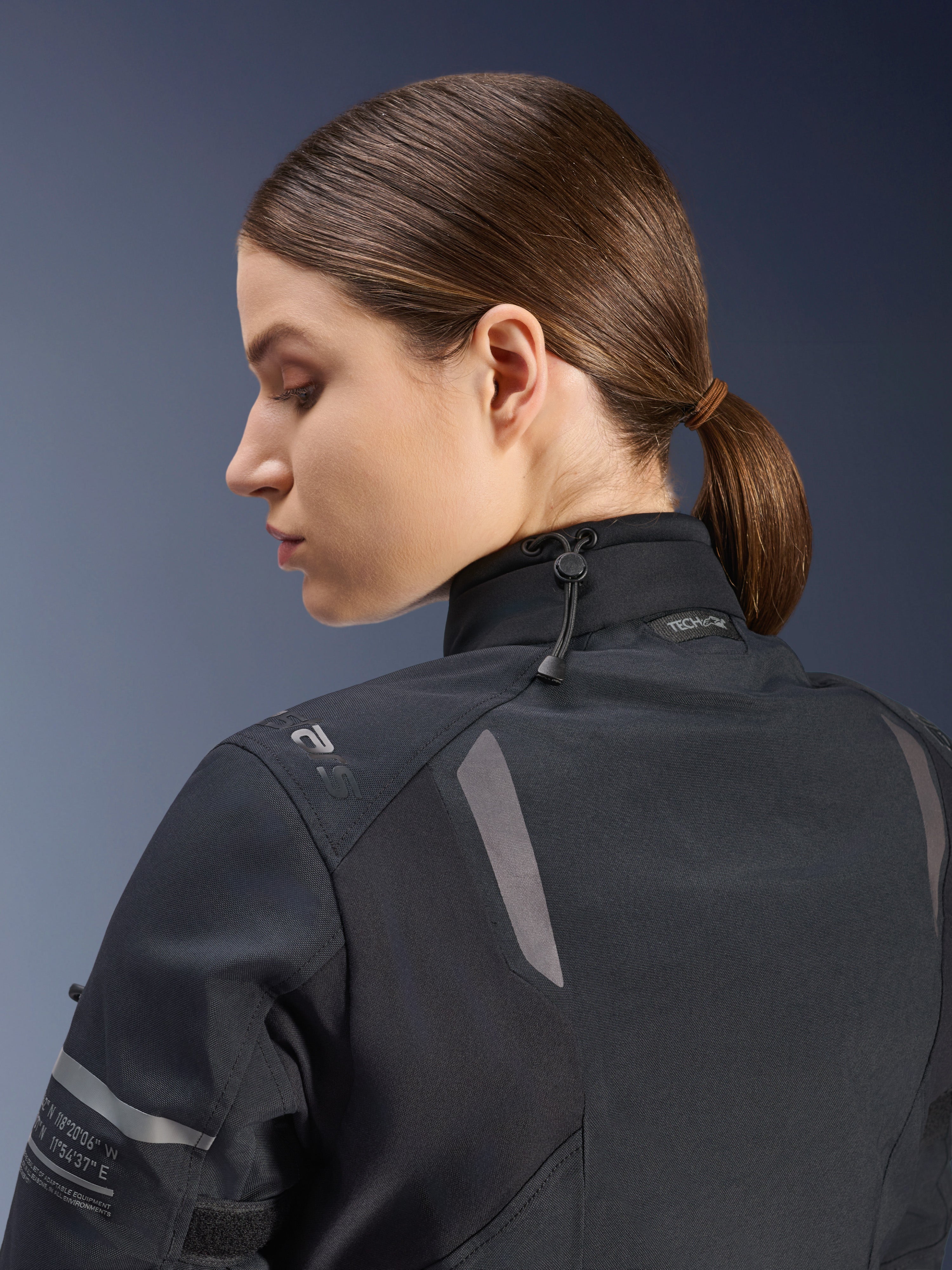 Veste Alpinestars Stella ST-7 2L GORE-TEX pour femme, veste de moto, noire, vue latérale arrière montrant la fermeture de col ajustable avec cordon, détails réfléchissants sur l'épaule et marquage Tech-Air Ready, design fonctionnel pour le touring d'aventure