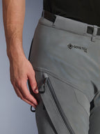 Gros-plan du pantalon Alpinestars Nazca 3L GORE-TEX PRO en gris foncé noir, montrant le marquage GORE-TEX PRO sur la hanche, une poche cargo zippée résistante à l'eau et une construction textile durable pour la conduite aventure.