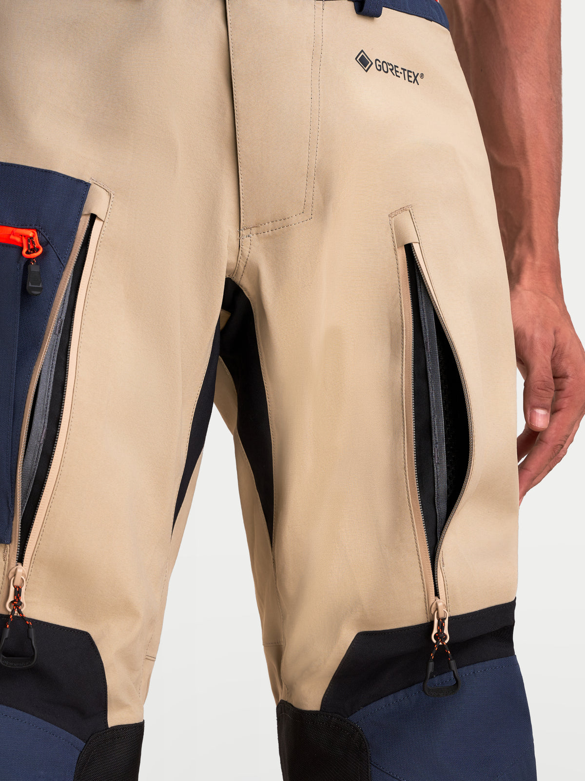 Alpinestars Arenis Gore-Tex Pantalons, pantalon de moto adventure pour homme, vue rapprochée des zips de ventilation sur les cuisses et marquage GORE-TEX en beige, bleu marine et noir