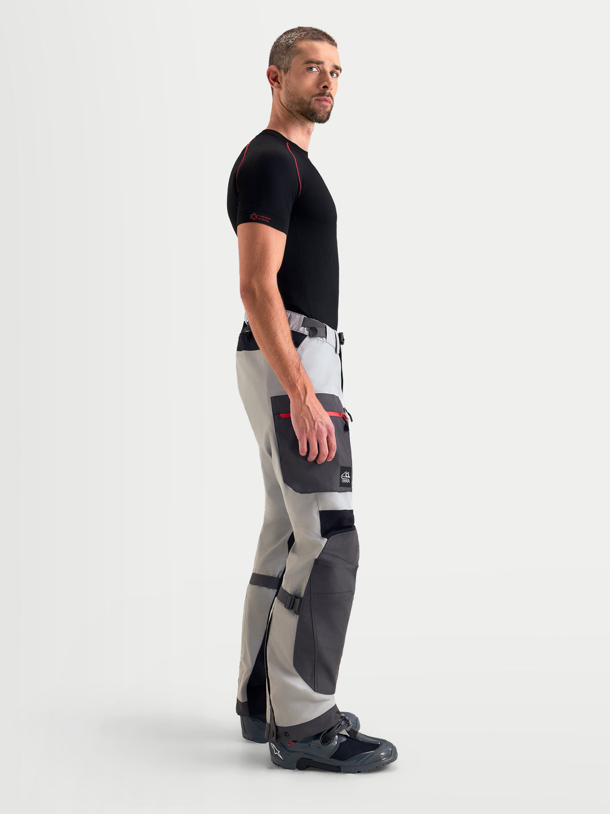 Alpinestars Arenis Gore-Tex Pantalons, pantalon de moto adventure pour homme gris moyen, gris foncé et noir, vue de profil montrant la construction textile imperméable et la poche cargo porté par un modèle