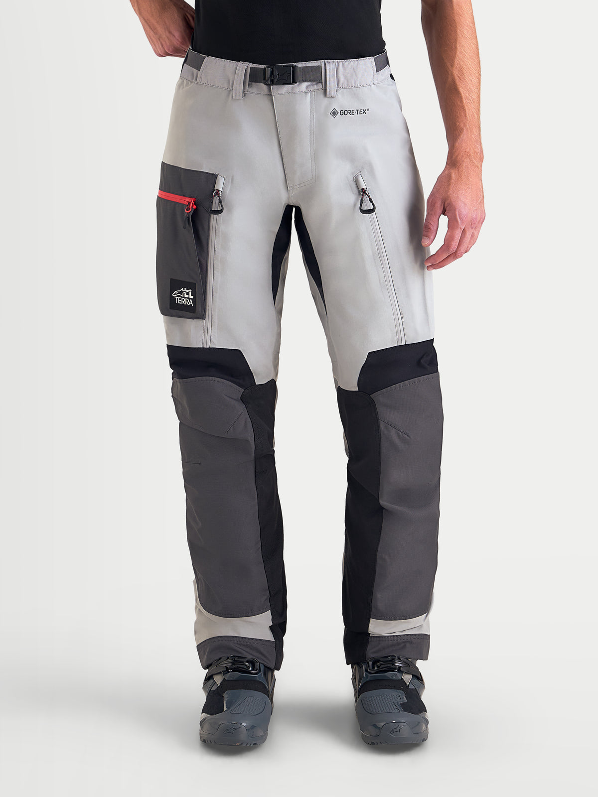 Alpinestars Arenis Gore-Tex Pantalons, pantalon de moto adventure pour homme en gris moyen, gris foncé et noir, vue de face sur un modèle portant un équipement en textile imperméable avec poches sur les cuisses et zips de ventilation