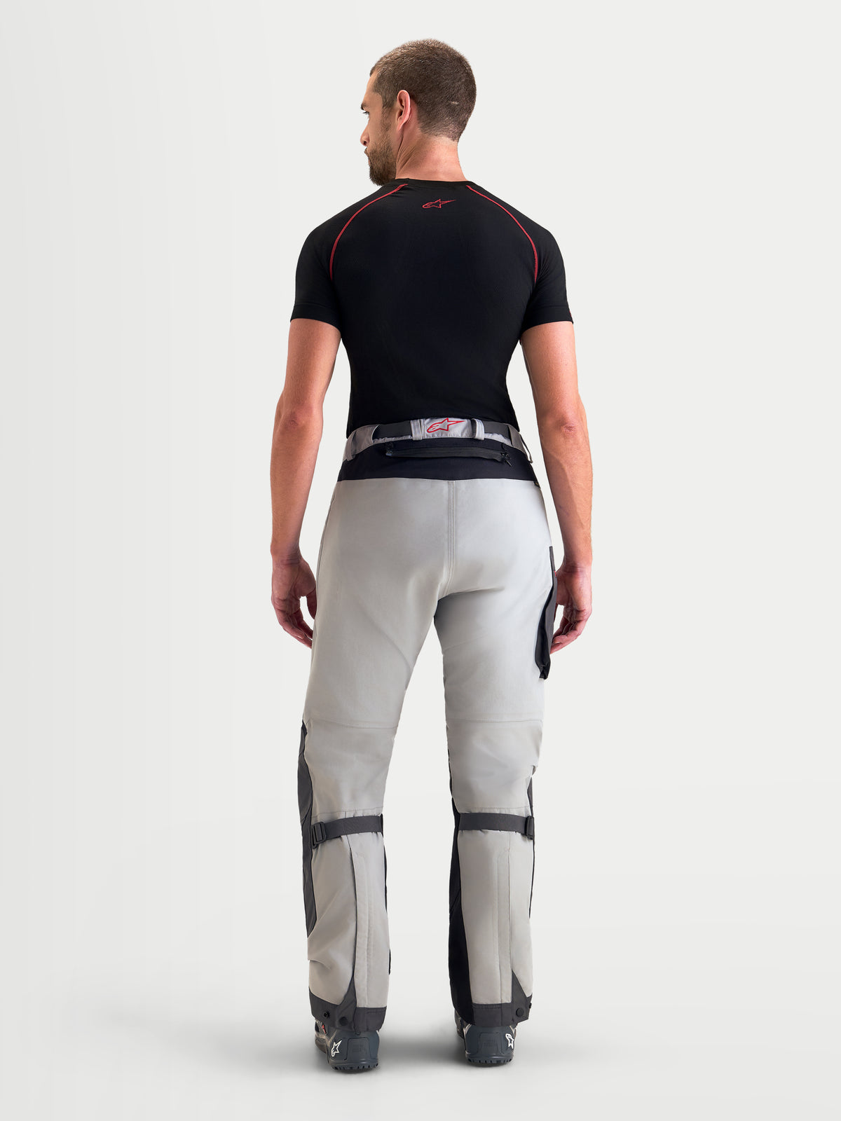 Alpinestars Pantalon Arenis Gore-Tex, pantalon de moto adventure pour homme gris et noir, vue de dos sur un modèle montrant la construction en textile imperméable et le système d'ajustement à la taille