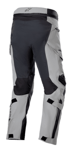 Pantalon Alpinestars Boulder 3L GORE-TEX, pantalon de moto aventure, gris foncé et noir, vue de trois-quarts arrière montrant l'assise renforcée et l'intérieur des jambes, panneaux gris clair, logo GORE-TEX sur le mollet et poches cargo ergonomiques.