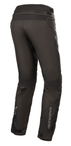 Pantalon Alpinestars Stella Road Pro GORE-TEX pour femme, noir, vue de trois quarts arrière, pantalon de moto en textile technique avec marquage Alpinestars réfléchissant sur le bas de la jambe, doté d'une coupe fuselée, d'ajusteurs de jambe en velcro et d'une fermeture éclair de raccordement à la taille pour le touring aventure.
