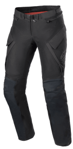 Pantalon Alpinestars Stella ST-7 2L GORE-TEX pour femme, pantalon de moto Adventure Touring, noir et gris foncé, vue de face avec poches cargo, boucle de taille magnétique, genoux articulés avec positionnement des protections et marquage Alpinestars discret sur la cuisse.