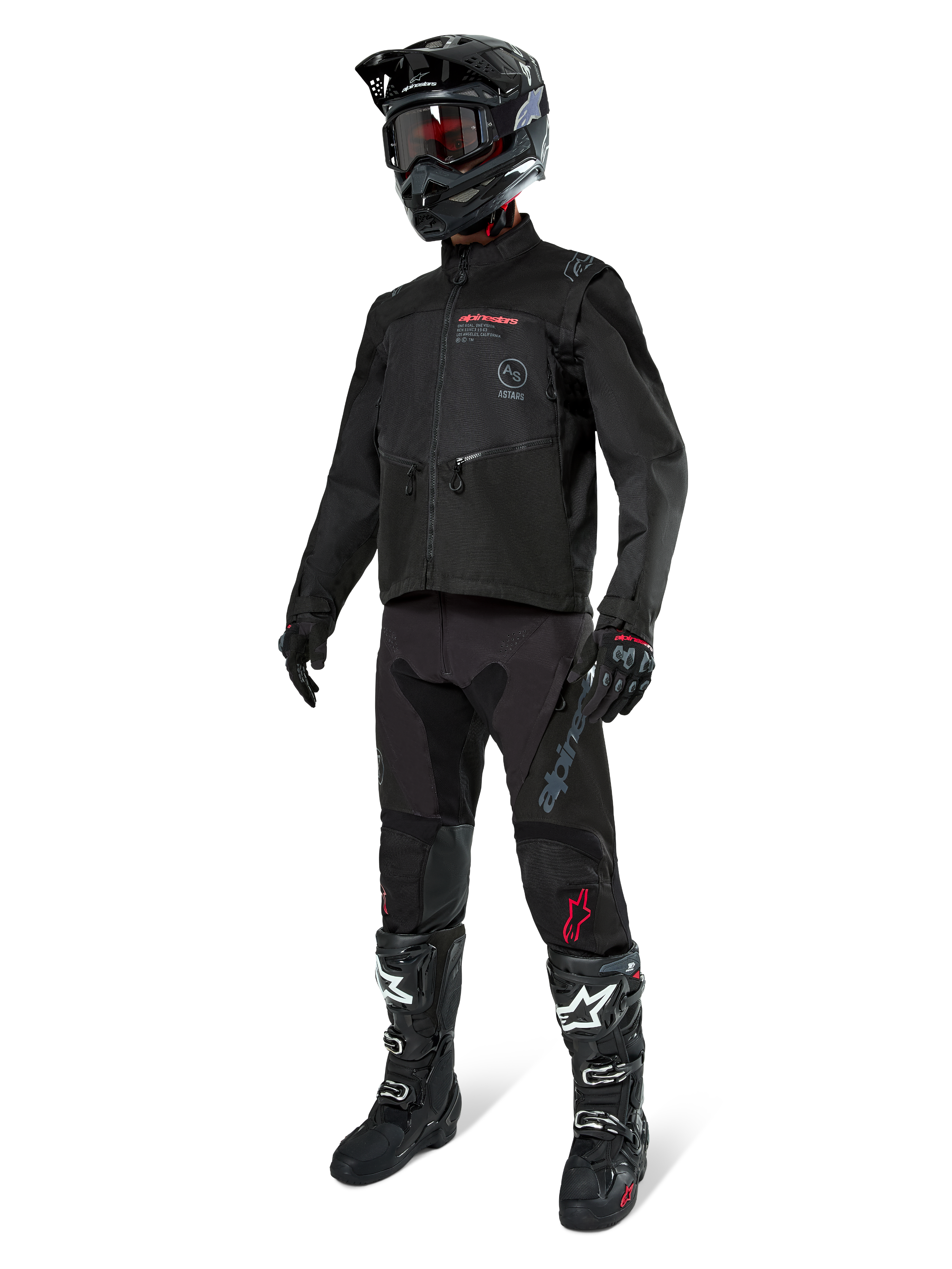 Pilote de motocross portant un équipement de course complet, veste Alpinestars Pro-Dura noire, pantalon noir avec marquage gris et accents rouges, casque noir avec lunettes, et bottes de motocross noires et blanches, tenue coordonnée pour l'enduro et le tout-terrain