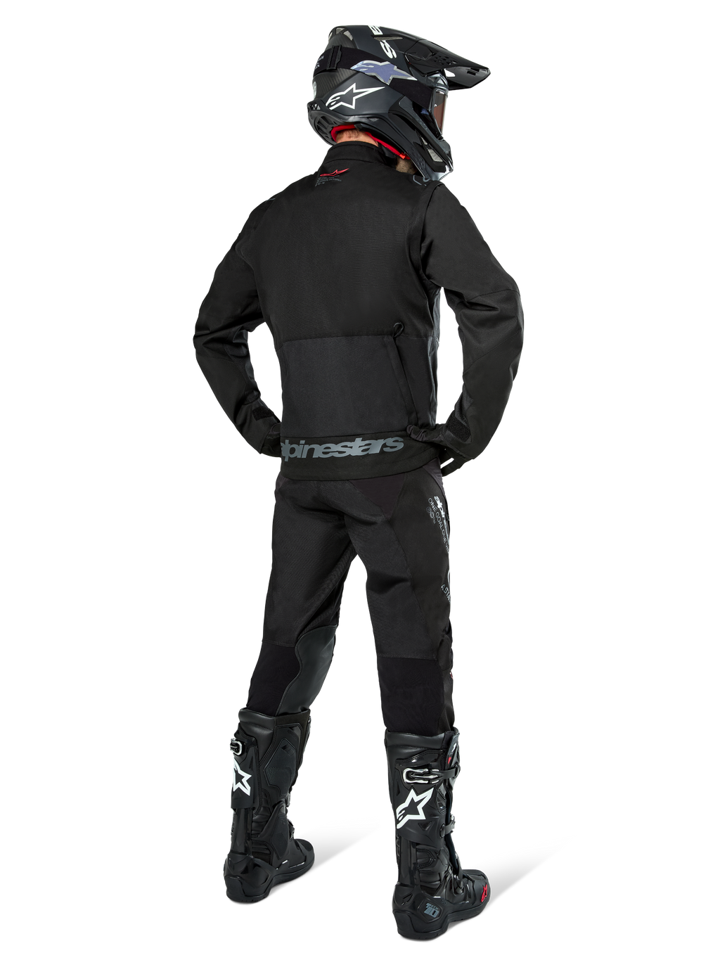 Veste Alpinestars Pro-Dura, veste d'enduro tout-terrain noire, vue arrière portée avec le pantalon assorti et des bottes Tech 10 noires, logo Alpinestars distinctif dans le bas du dos, construction en textile robuste pour une conduite agressive sur sentier