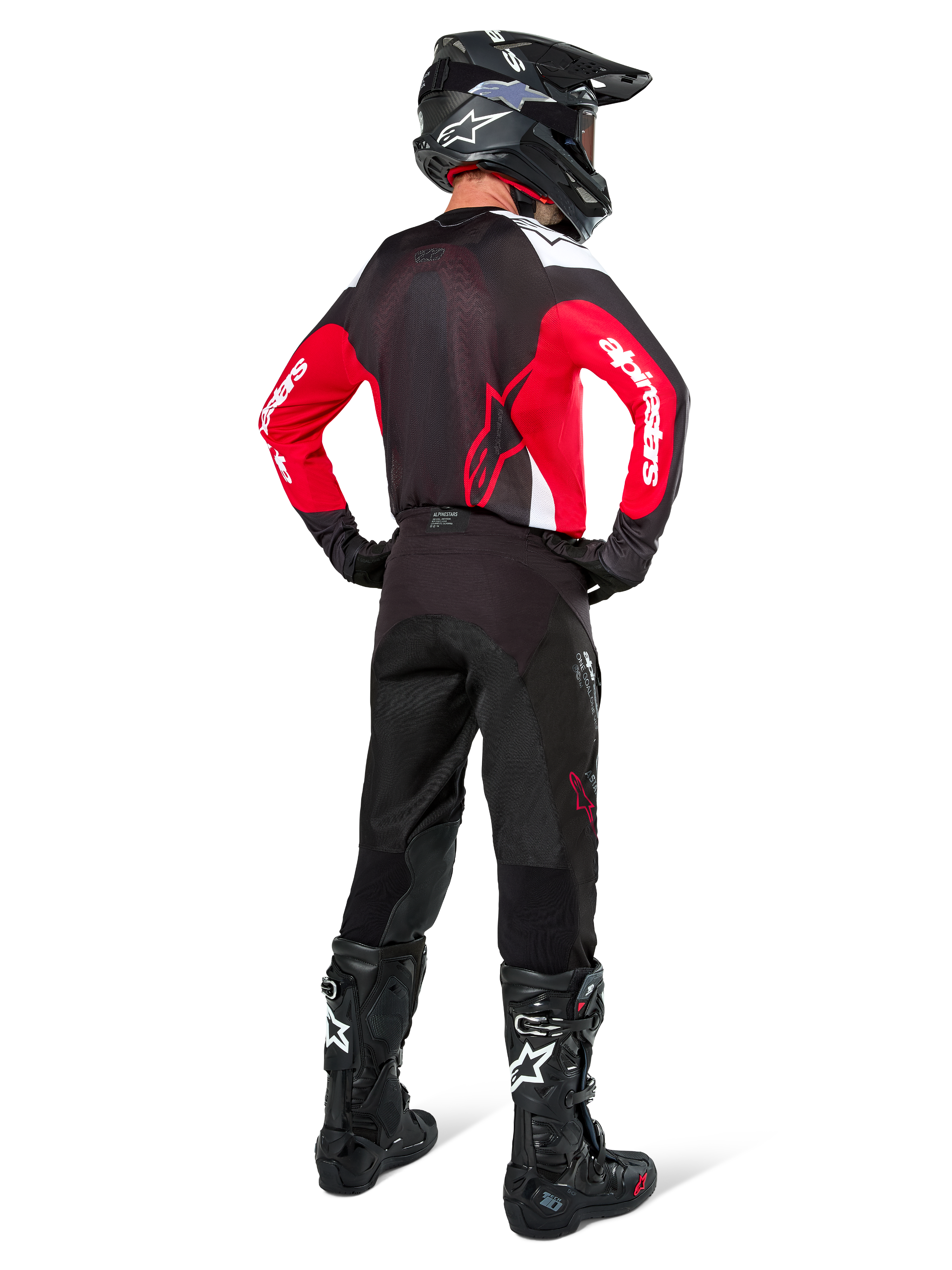 Motocross rider from behind wearing Alpinestars Pro-Dura Pants in Black Magnet White, paired with a red and black jersey and black boots, coordinated off-road gear set for enduro riding