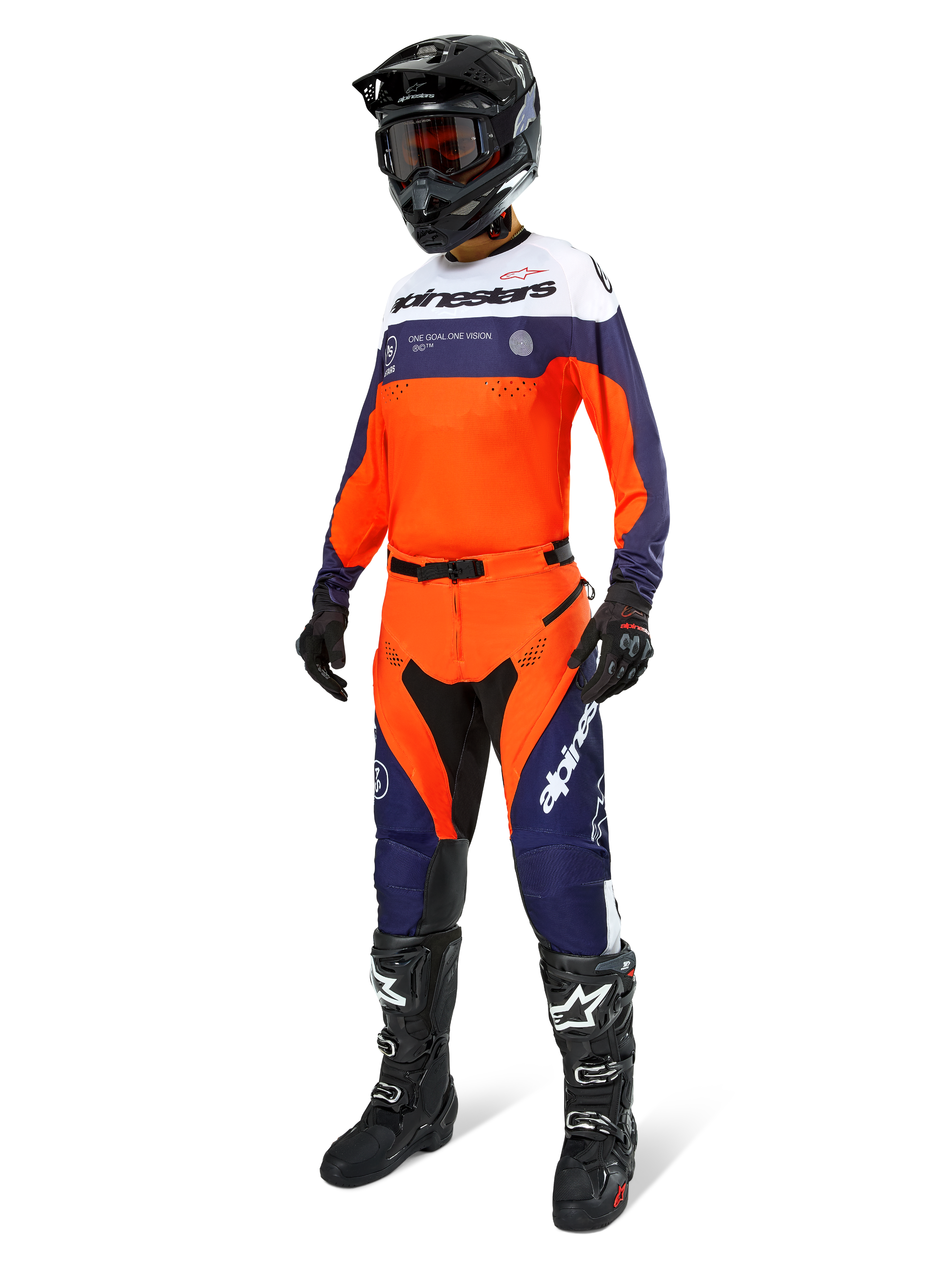 Pantalon Alpinestars Pro-Dura, pantalon de motocross et d'enduro, bleu navy, orange vif et blanc, porté avec une tenue de course complète comprenant un maillot assorti, un casque noir et des bottes noires, doté de panneaux durables et d'un marquage distinctif pour des performances tout-terrain