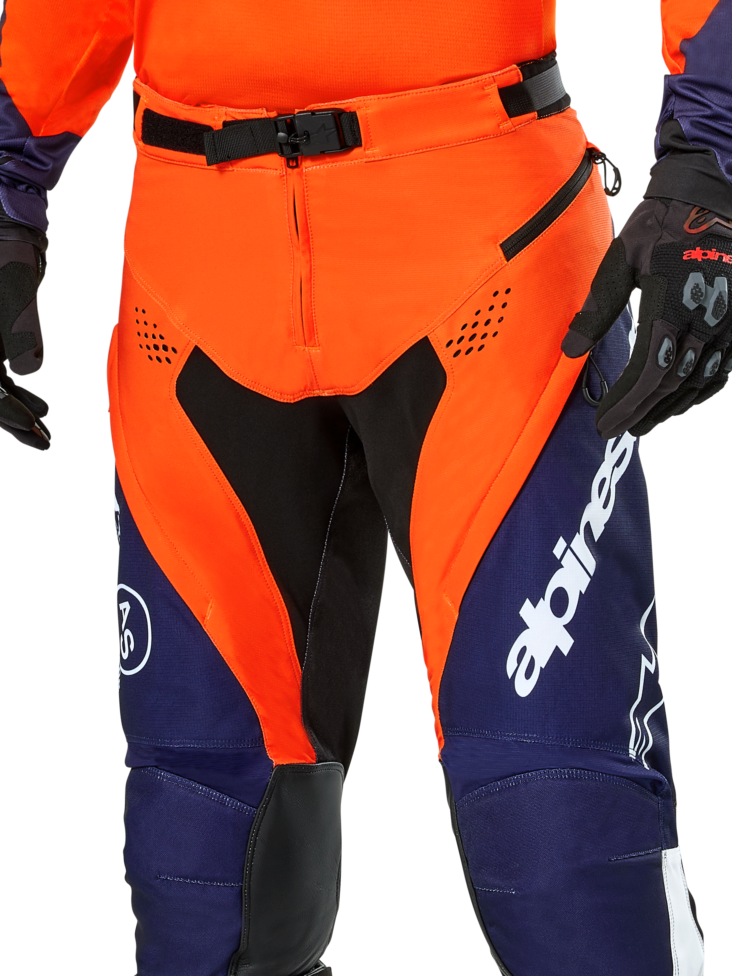 Pantalon Alpinestars Pro-Dura, pantalon de moto enduro, bleu marine, orange vif et blanc, vue détaillée de la taille avec boucle magnétique SX2 et ouvertures d'aération zippées sur les cuisses, matériau ripstop durable avec marquage distinctif, porté avec l'équipement assorti