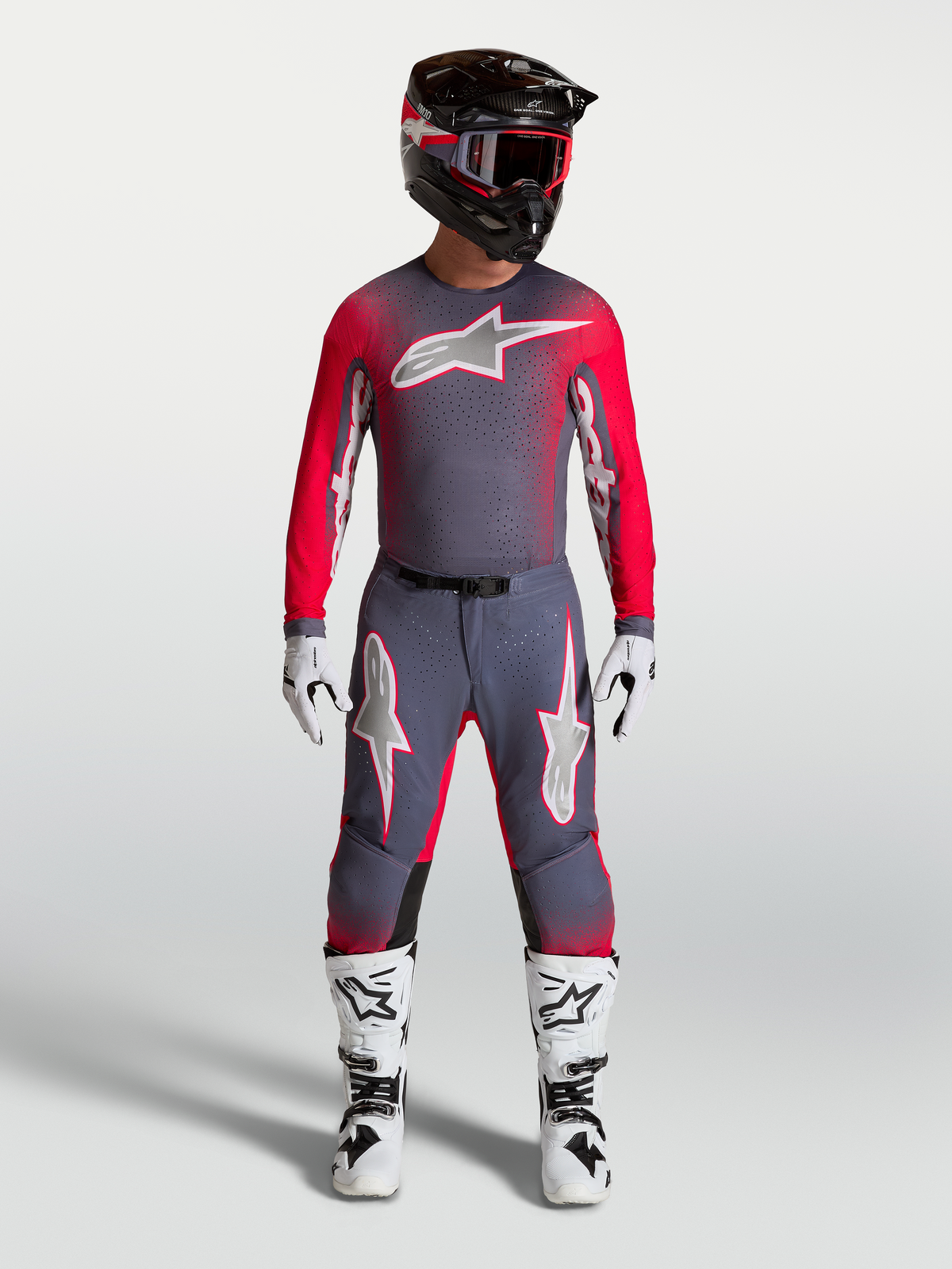 Alpinestars Supertech Hiten AFD Gear Set et Pantalon, tenue de motocross pour homme, gris et rouge fluo, avec bottes blanches.