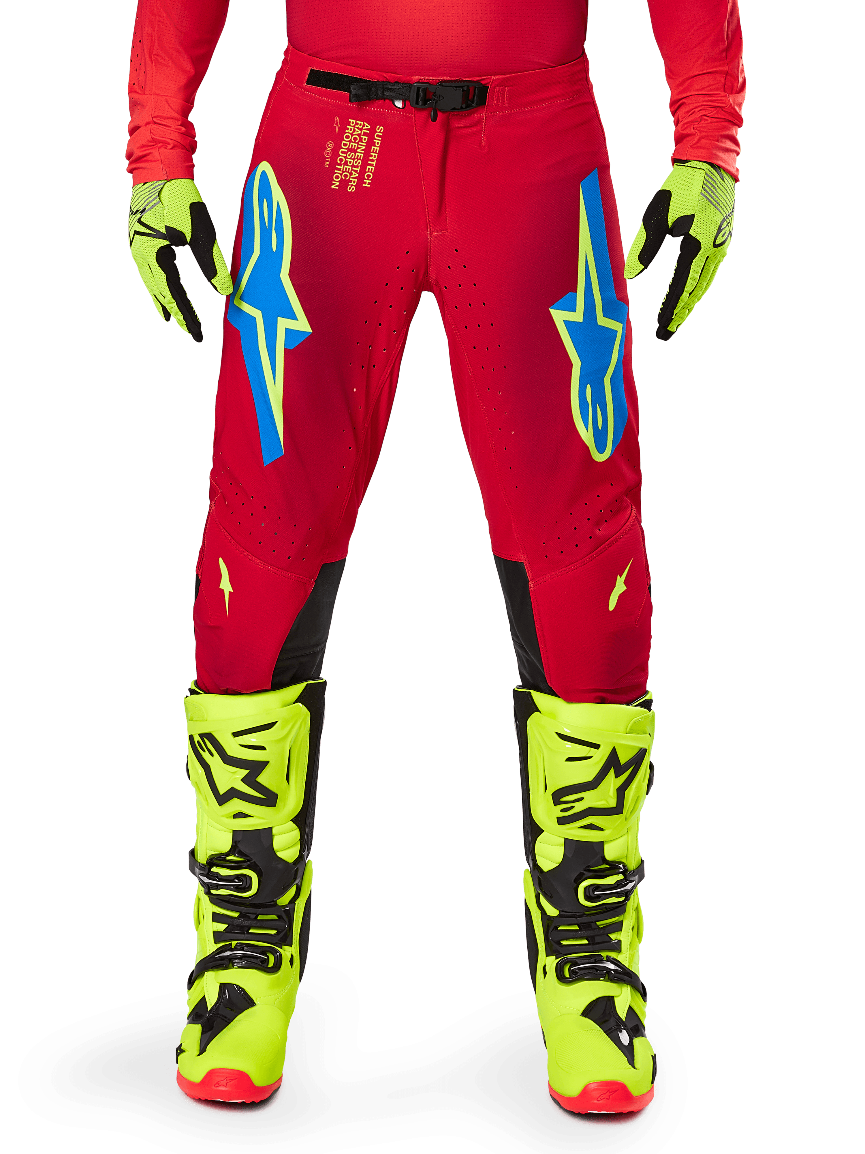 Pantalon Alpinestars Supertech Maker 2025, pantalon de motocross, rouge vif et jaune fluo, avec logos Astars bleus sur les cuisses, perforations de ventilation et panneaux intérieurs noirs aux genoux, porté avec des bottes et des gants jaune fluo assortis