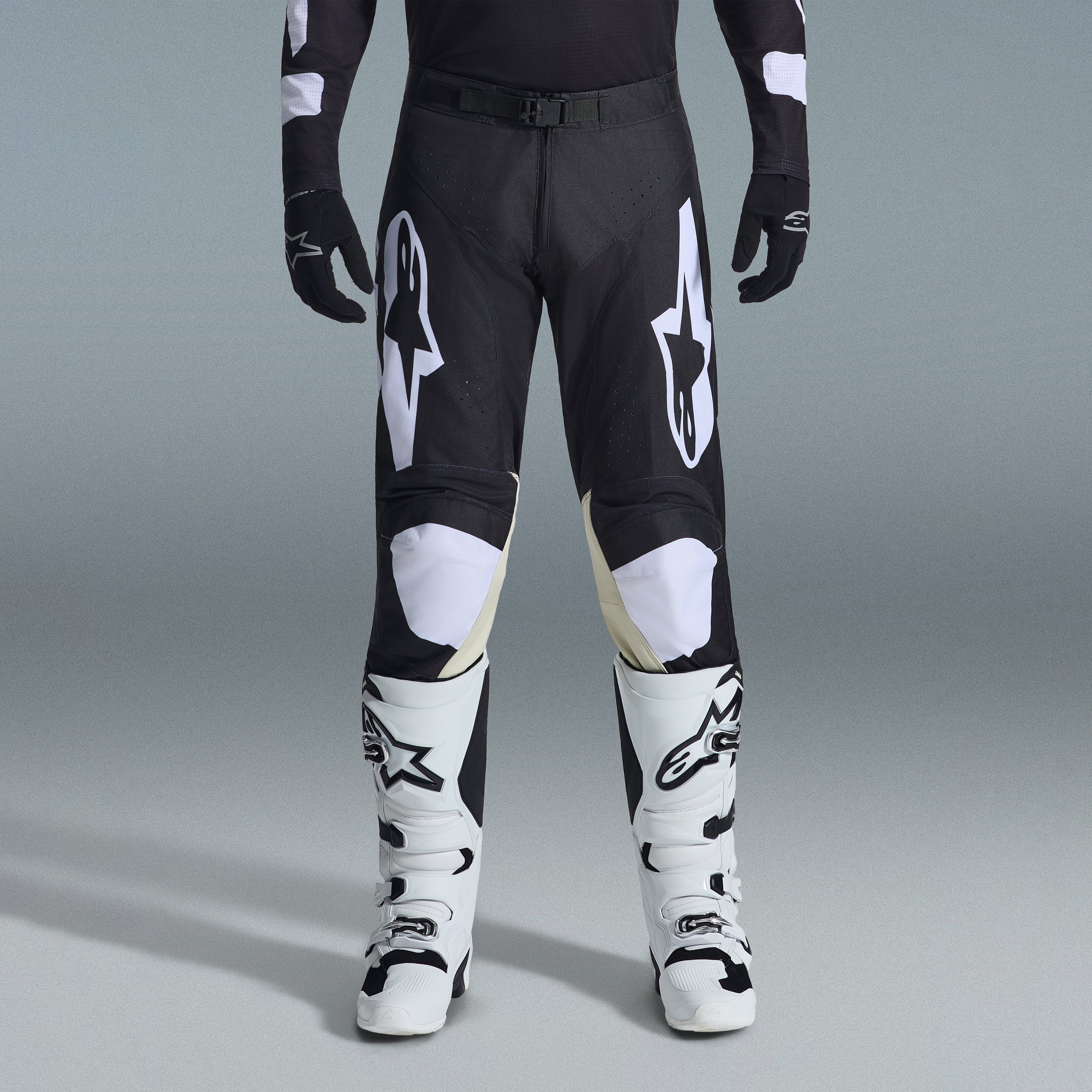 Ensemble d'équipement Alpinestars Racer Air Riway 2026, pantalon de motocross noir et blanc avec panneaux intérieurs aux genoux beiges, associé à des bottes de course blanches et des gants noirs, équipement de course tout-terrain léger et ventilé