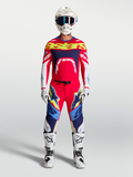 Alpinestars Supertech Dyna Gear Set AND Pantalon Supertech Dyna, ensemble de motocross pour homme, rouge et bleu marine, coupe athlétique pro-rider, tenue de course complète avec casque et bottes blanches.