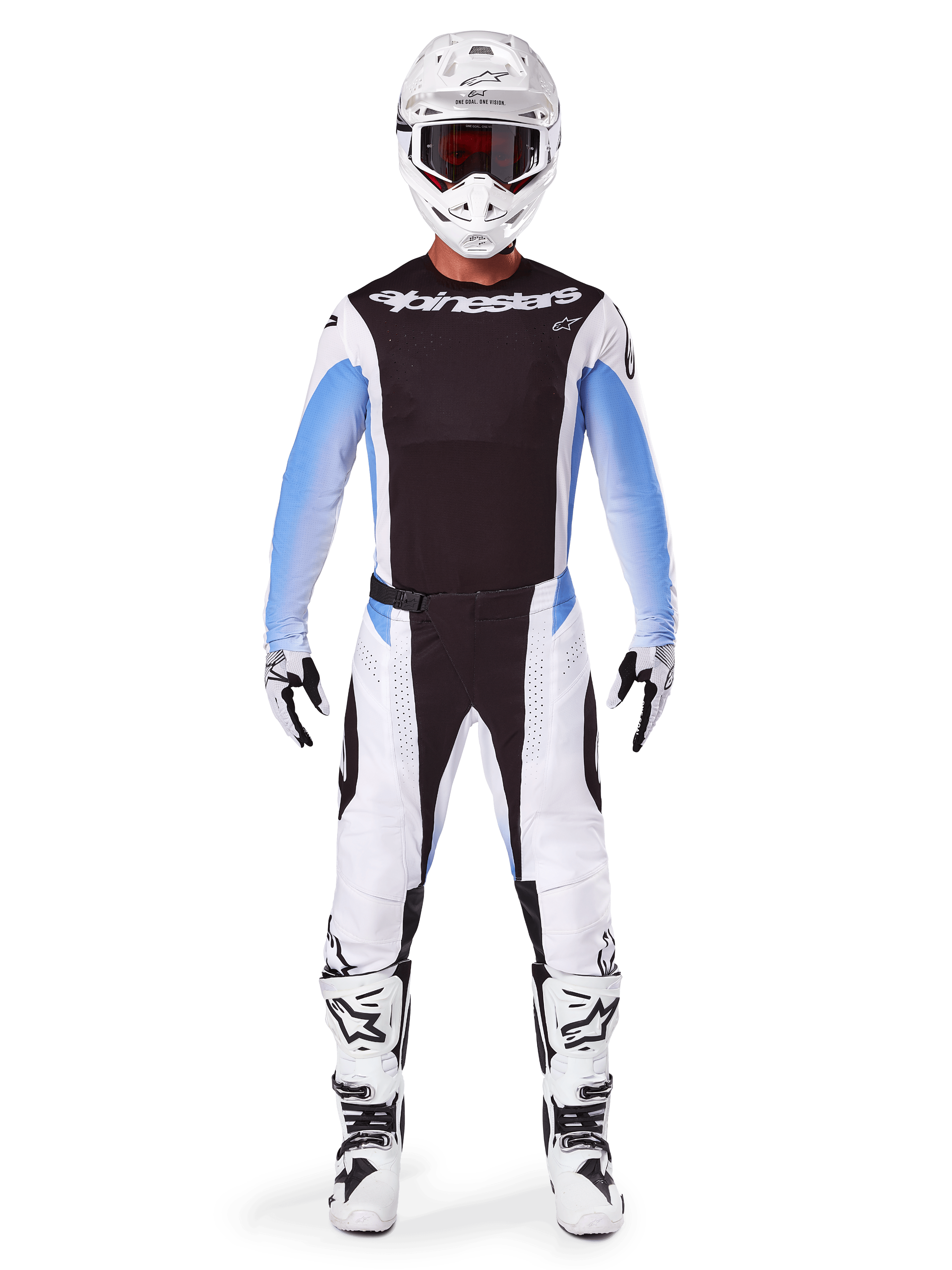Pilote de motocross portant le pantalon Alpinestars Techstar Melt 2025, pantalon de motocross, noir et bleu, design multi-panneaux blanc et noir avec des accents bleus sur les hanches, porté avec un maillot blanc assorti, un casque blanc, des gants blancs et des bottes pour un équipement de course tout-terrain complet