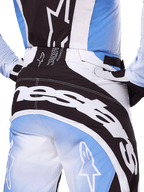 Alpinestars Techstar Melt Pants 2025, pantalon de motocross, noir, blanc et bleu, vue arrière rapprochée avec logo blanc imposant sur l'assise, coordonné avec le maillot et les gants Techstar Melt assortis, équipement de course professionnel pour le motocross
