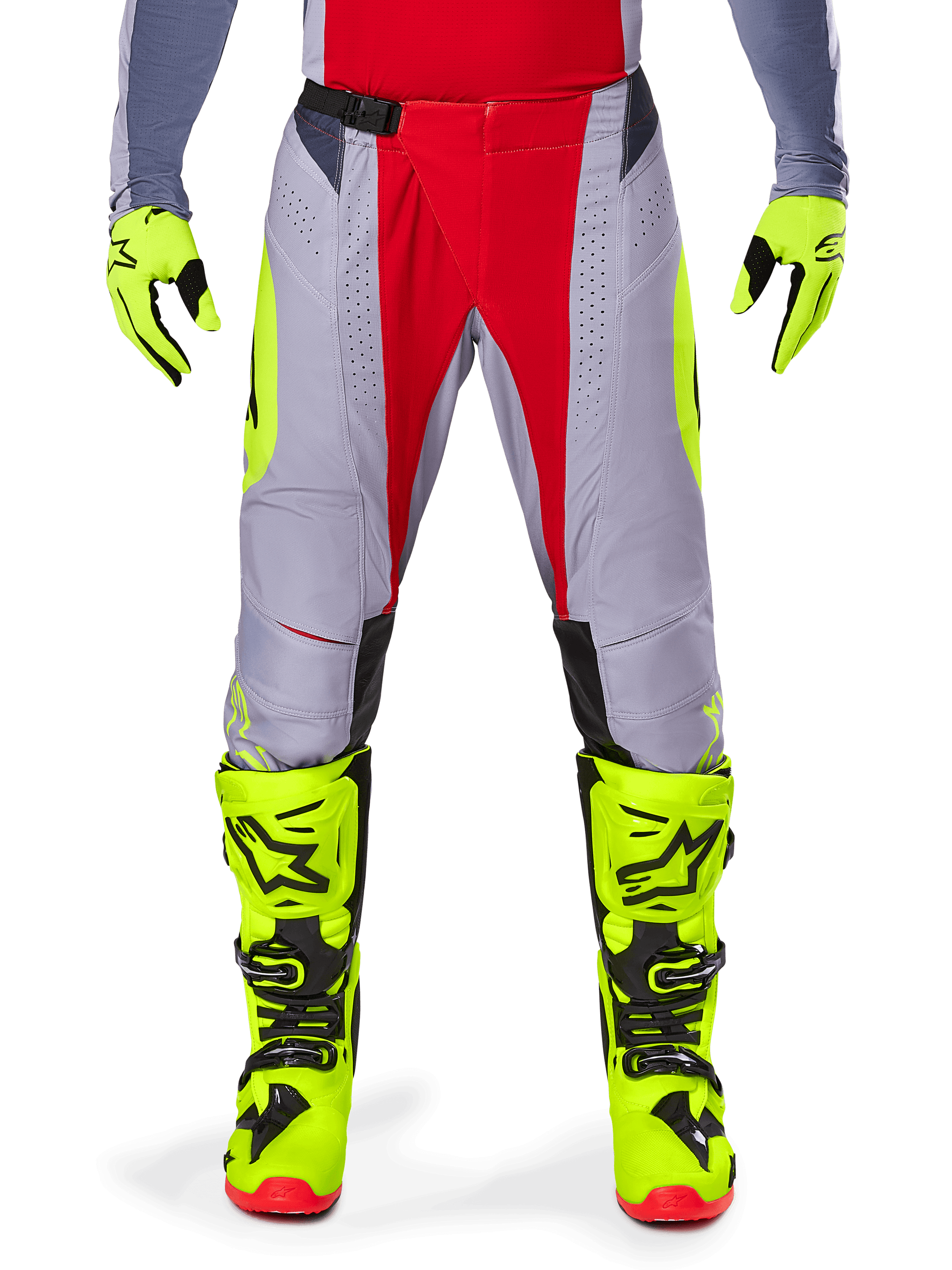 Alpinestars Techstar Melt Pants 2025, pantalon de motocross, rouge et gris avec accents jaune fluo, perforations découpées au laser pour la ventilation, porté avec des gants et des bottes jaune fluo, équipement haute performance pour la course tout-terrain