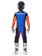 Pilote de motocross portant une tenue de course complète, ensemble d'équipement Alpinestars Techstar Melt 2025, bleu et orange, maillot bleu avec manches orange, pantalon assorti avec logos blancs, casque noir avec lunettes bleues, bottes et gants blancs et noirs, tenue coordonnée pour la course tout-terrain