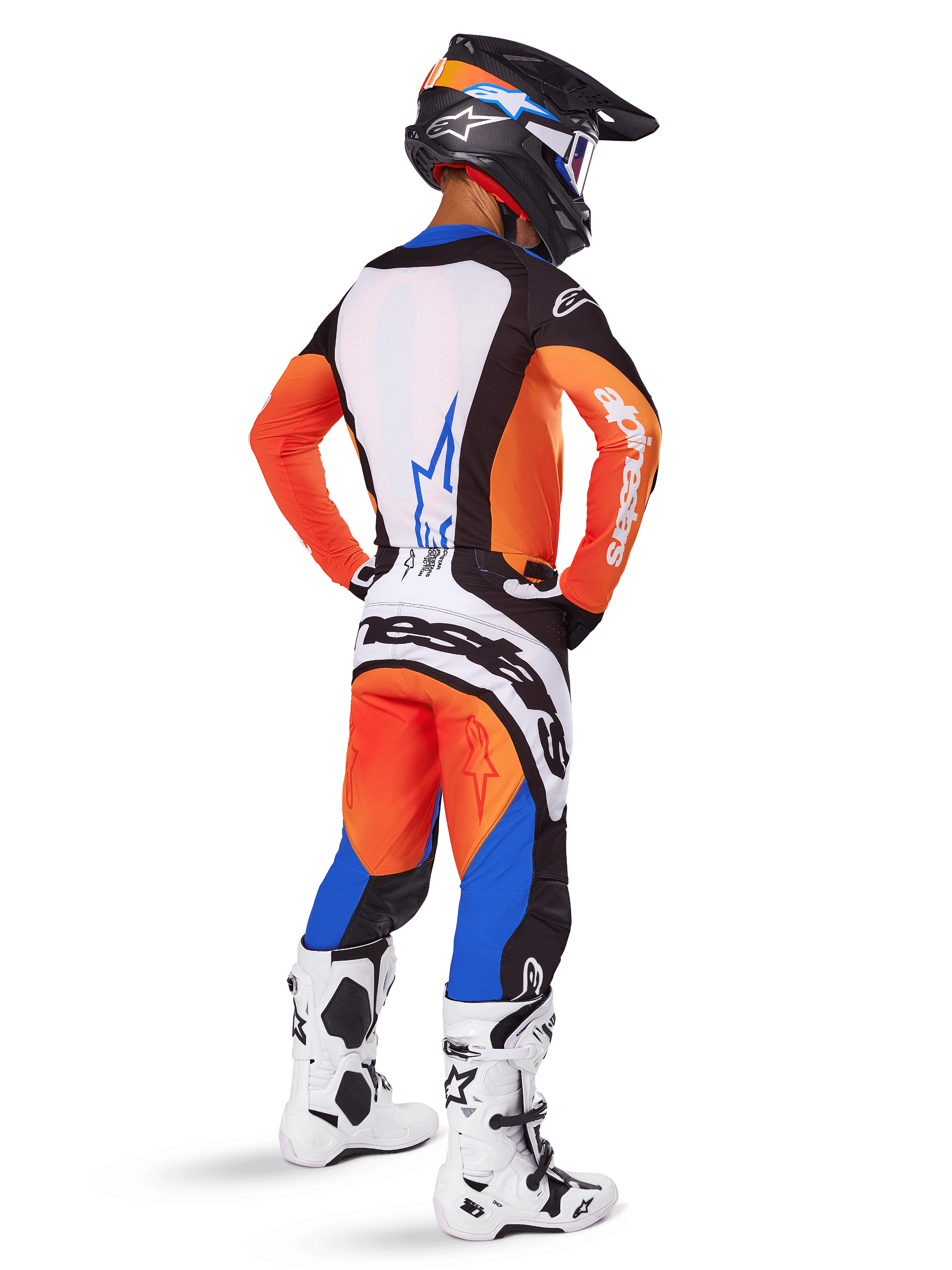 Pilote de motocross vu de dos portant l'ensemble d'équipement Alpinestars 2025 Techstar Melt, maillot orange et bleu avec panneau arrière blanc et pantalon assorti, avec marquage blanc imposant, casque de motocross noir et bottes de course blanches.