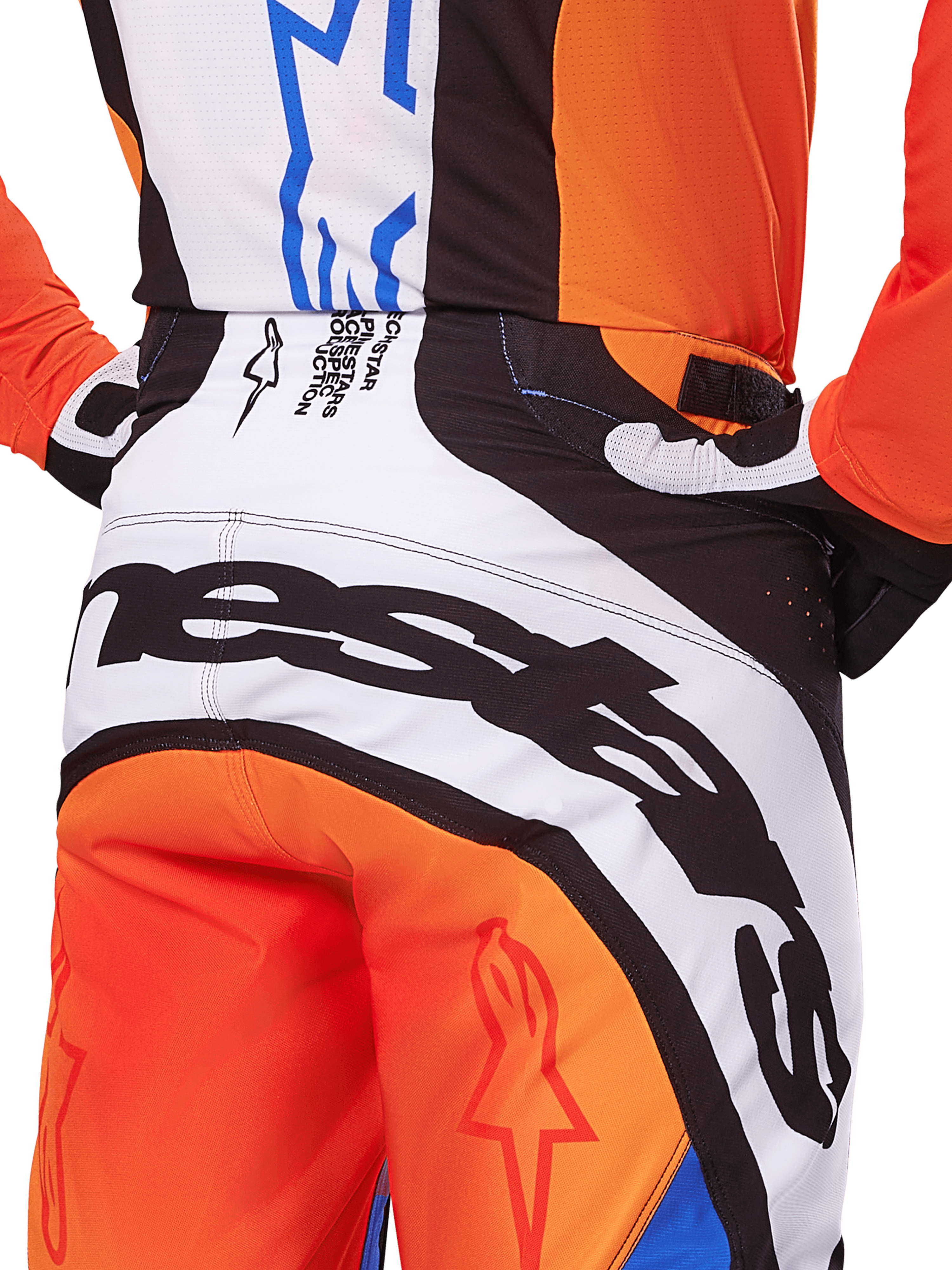 Alpinestars Techstar Melt Pants 2025, pantalon de motocross, orange et bleu, vue arrière rapprochée de l'assise et de la taille, marquage noir audacieux sur fond blanc, panneaux orange avec logos étoiles rouges, équipement de performance athlétique pour la course tout-terrain