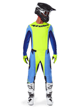 Alpinestars 2025 Techstar Melt Pants, pantalon de motocross, jaune fluo et bleu, porté avec un maillot assorti, des gants jaunes et des bottes blanches et noires, avec un casque noir et des lunettes rouges, ensemble complet d'équipement de course pour la performance tout-terrain