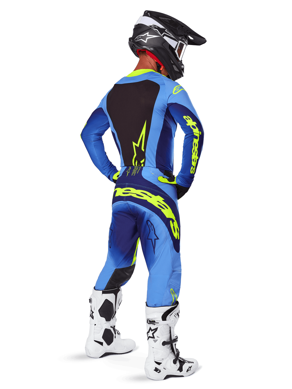 Alpinestars Techstar Melt Pants 2025, équipement de motocross, jaune fluo et bleu, vue arrière du pilote portant un maillot bleu assorti avec un large marquage jaune, des bottes blanches et noires et un casque noir, tenue de course coordonnée pour la performance tout-terrain