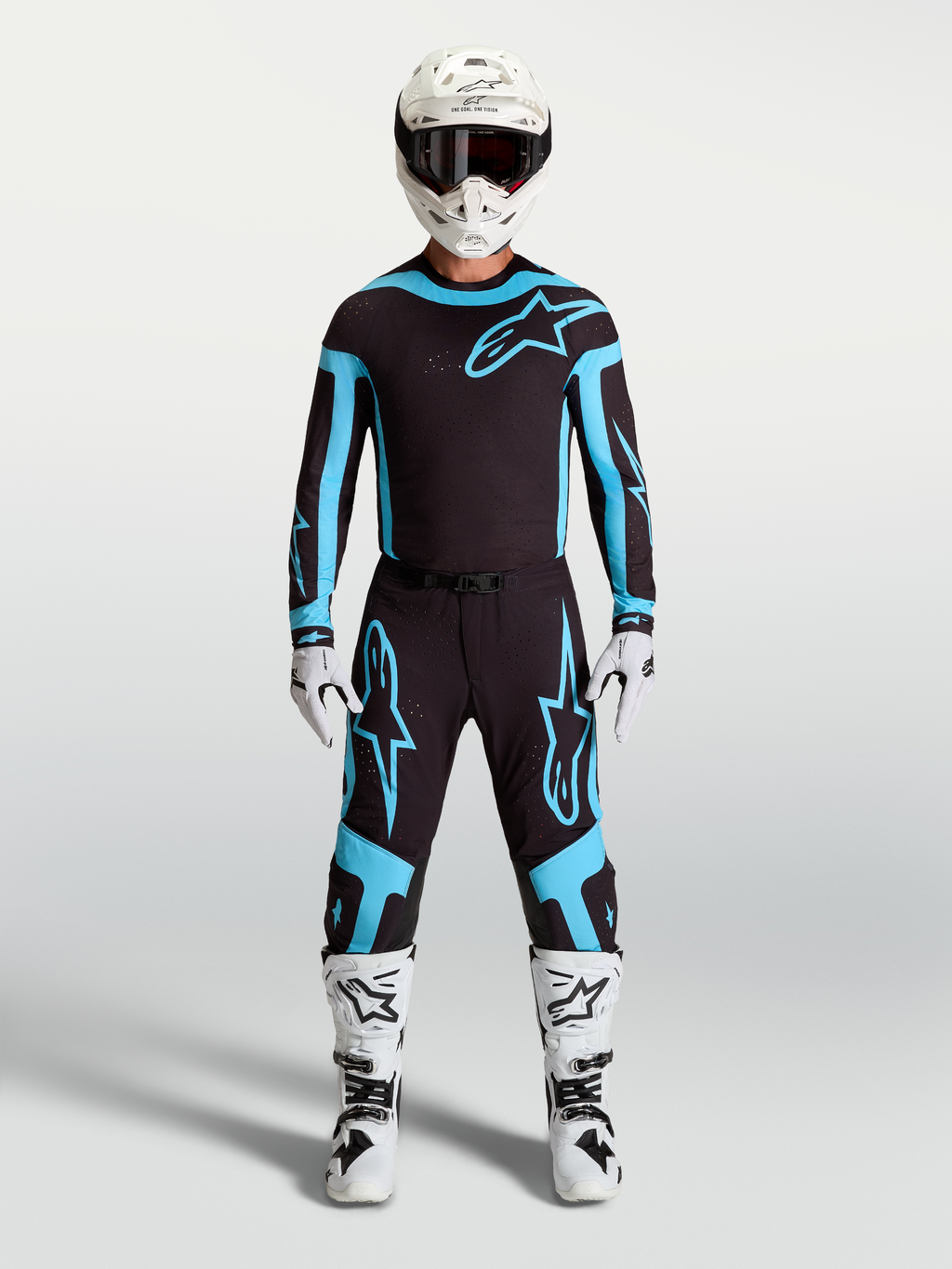 Pantalon Alpinestars Supertech Vesta, équipement de motocross pour homme, noir et turquoise, tissu extensible léger et coupe athlétique, porté par un mannequin avec bottes et casque