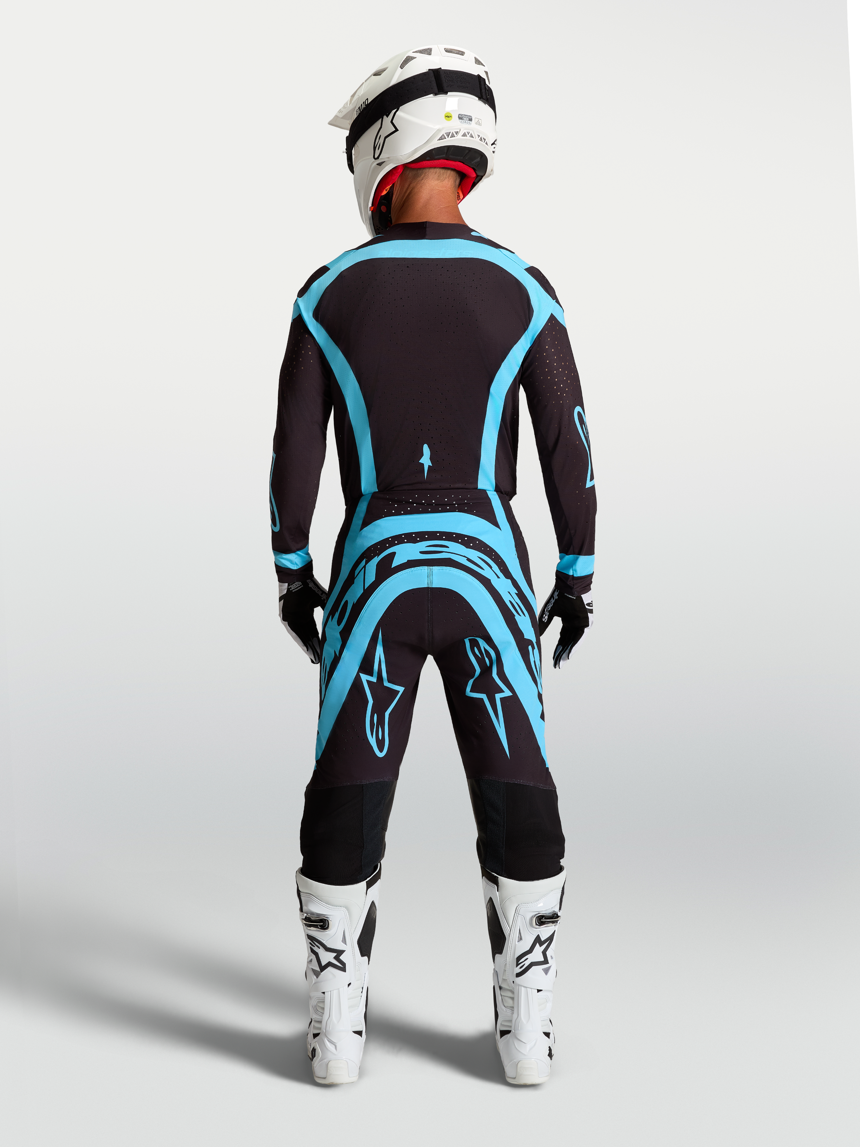 Alpinestars Supertech Vesta, pantalon de motocross professionnel pour homme, noir et turquoise, vue de dos sur mannequin, équipement tout-terrain haute performance avec coupe athlétique.