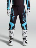 Alpinestars Pantalon Supertech Vesta, équipement motocross pro pour homme, noir et bleu turquoise avec larges graphismes d'étoiles et panneaux de genoux en cuir, porté par un pilote.