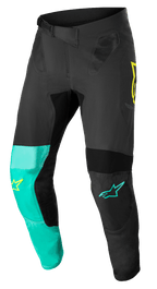 Alpinestars Supertech Blaze Pants, Motocross Pants, Black, Pastel Green and Yellow Fluo, featuring asymmetrical leg panels with yellow and teal star logos, mesh ventilation inserts, and adjustable ratchet waist belt for off-road racing