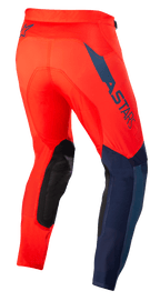 Alpinestars Supertech Blaze Pants, Motocross Pants, Bright Red and Dark Blue, Rear three-quarter view, featuring dark blue ASTARS logo on the side, black reinforced knee panels, and athletic fit for off-road performance.