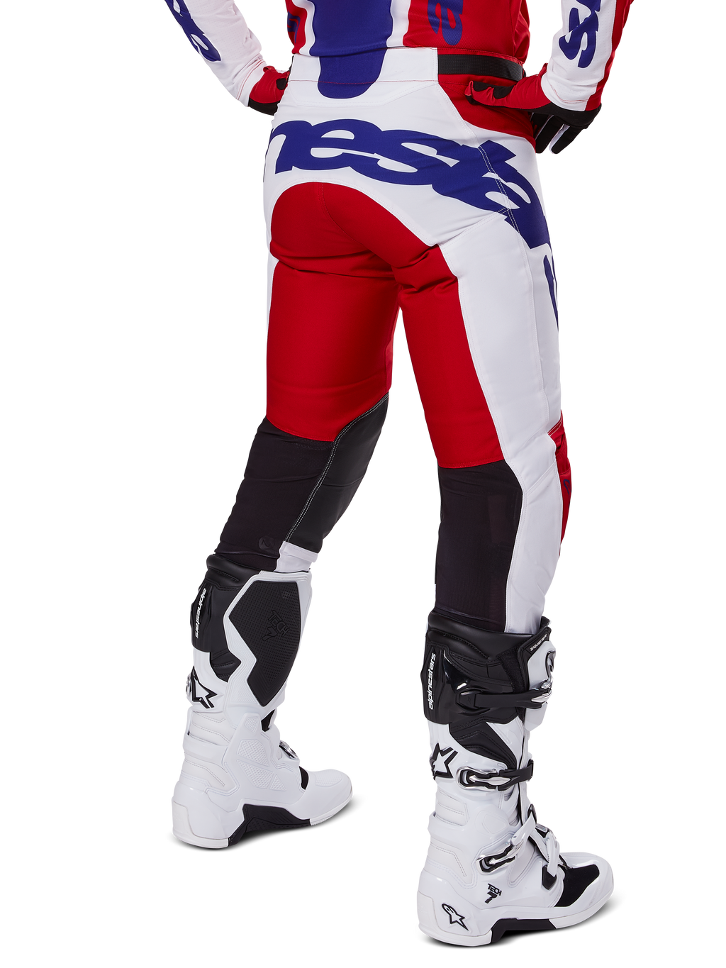 Alpinestars 2025 Racer Veil Pants, pantalon de motocross, rouge vif et blanc avec logo bleu, vue arrière montrant des empiècements de ventilation noirs extensibles à l'arrière des jambes, associé à des bottes de motocross blanches