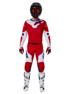 Alpinestars 2025 Racer Veil Pants et tenue de motocross complète, rouge vif et blanc avec accents bleus, comprenant un maillot assorti, un casque noir avec lunettes orange, des bottes blanches et noires, et des gants rouges, look de performance coordonné pour la course tout-terrain