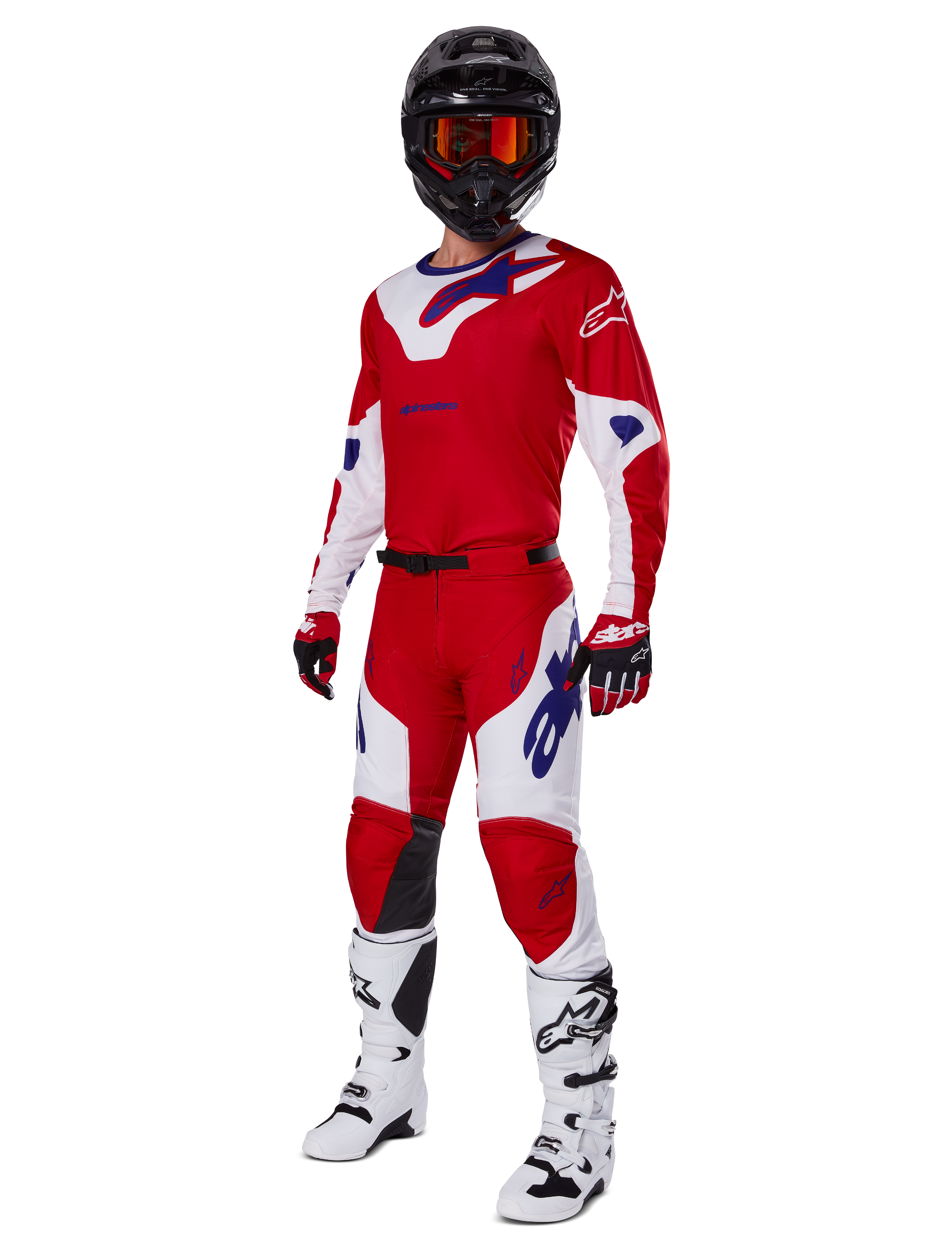 Alpinestars 2025 Racer Veil Pants, pantalon de motocross, rouge vif et blanc, porté dans le cadre d'un équipement de course complet comprenant un maillot rouge et blanc assorti, un casque noir avec des lunettes orange, des bottes blanches et des gants rouges, avec des logos Alpinestars bleus.