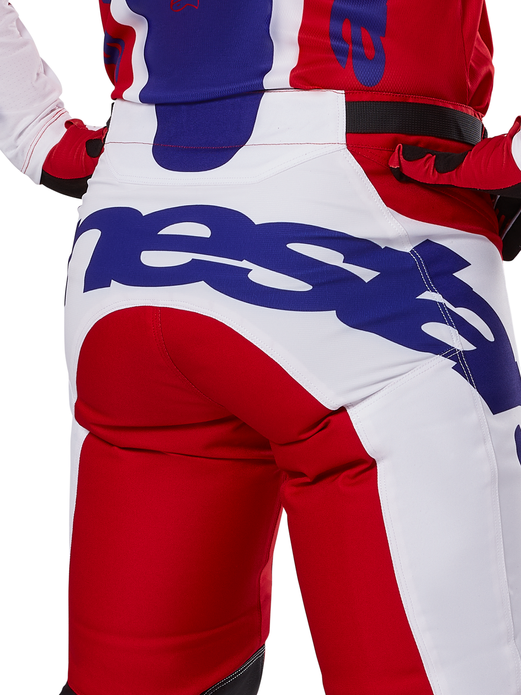 Alpinestars 2025 Racer Veil Pants, pantalon de motocross, rouge vif et blanc avec logo bleu, vue arrière détaillée de l'assise présentant un grand logo Alpinestars, porté dans le cadre d'une tenue de course tout-terrain coordonnée